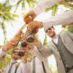 low angle of men holding beer bottles and having a toast